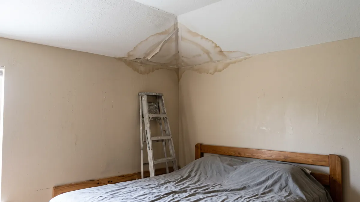 Water stain and sagging drywall spreading from a bedroom ceiling corner in an Irving home